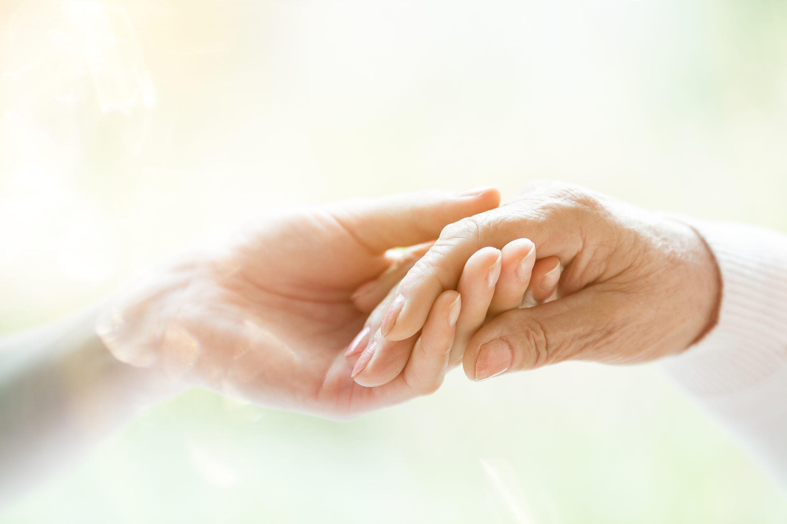 Young hand holding elderly hand