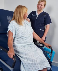 patient sat on bed next to nurse